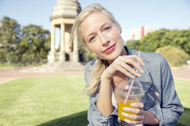 Young woman in park with soft drink - TOYF000550