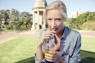 Young woman in park with soft drink - TOYF000551