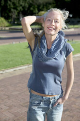 Portrait of young woman standing in park - TOYF000578