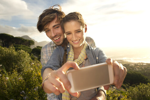 Glückliches junges Paar macht ein Selfie an der Küste - TOYF000582