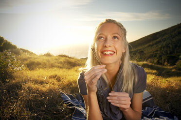 Smiling young woman in remote landscape looking up - TOYF000597