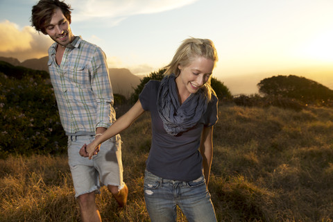 Young couple walking hand in hand in remote landscape stock photo