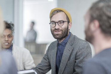 Man with glasses and yellow beanie in meeting with collegues - ZEF005724