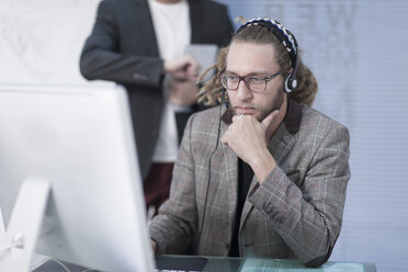 Man talking on a headset behind computer - ZEF005767