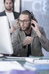 Man talking on a headset behind computer - ZEF005768