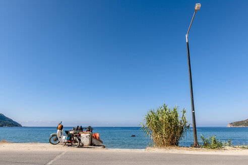 Griechenland, Korfu, Agios Georgios, Moped und Straßenlaterne am Meer - EGBF000084