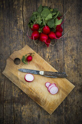 Organic radish on chopping board and pocket knife - LVF003384