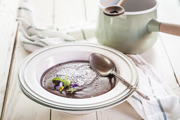 Plate of chocolate pudding decorated with edible flowers - SBDF001858