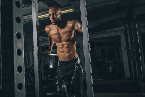 Junger Mann übt Dips am Power Rack im Fitnessstudio - MADF000302