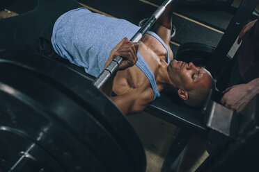 Junger Mann beim Bankdrücken im Fitnessstudio - MADF000306