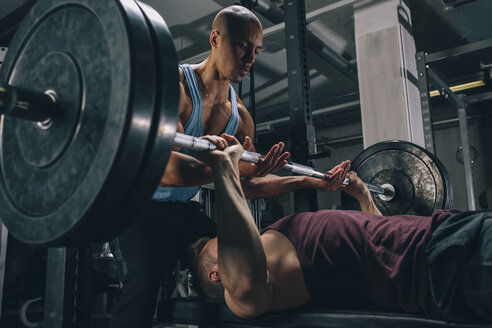 Zwei Freunde beim Bankdrücken im Fitnessstudio - MADF000310