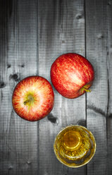 Glass of apple juice and two apples on wood - KSWF001530