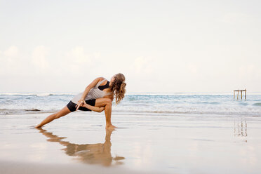 Sri Lanka, Kabalana, young woman practicing yoga on the beach - WV000746