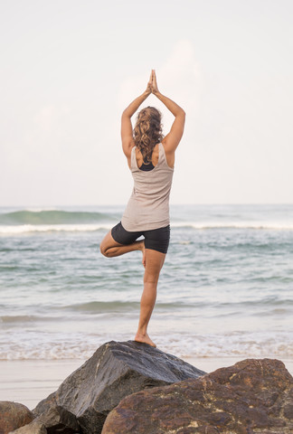 Sri Lanka, Kabalana, junge Frau übt Yoga an der Küste, lizenzfreies Stockfoto