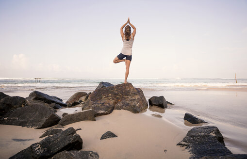 Sri Lanka, Kabalana, young woman practicing yoga on the beach - WV000750