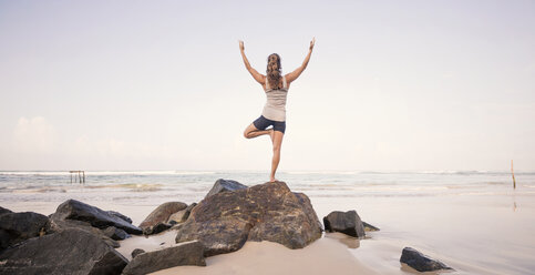 Sri Lanka, Kabalana, young woman practicing yoga on the beach - WV000751