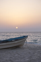 Oman, Ras al-Jinz, Sonnenaufgang und ein Fischerboot an der Küste - HLF000891