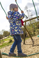 Kleines Mädchen balanciert auf einem Seil auf dem Spielplatz - JFEF000657