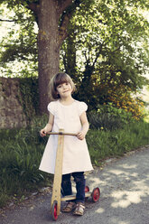 Porträt eines kleinen Mädchens mit altem Holz-Roller - LVF003390