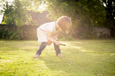 Little girl on a meadow using magnifying glass - LVF003397