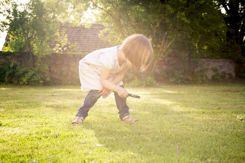 Kleines Mädchen auf einer Wiese mit Vergrößerungsglas - LVF003397