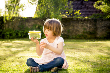 Kleines Mädchen mit Insektendose auf einer Wiese sitzend - LVF003400