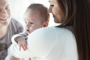 Lächelnde junge Eltern mit Baby - STKF001237