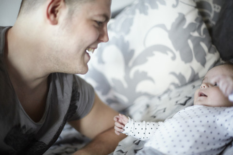 Lächelnder junger Vater mit Blick auf sein Baby, lizenzfreies Stockfoto