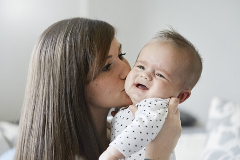 Junge Mutter tröstet weinendes Baby - STKF001271