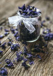 Glass jar and sweet violets on wood - MGOF000231