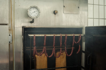 Preparation of smoked sausage, sausages getting smoked in smoke box - PAF001415