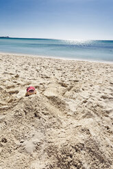 Portugal, Algarve, Kleiner Junge mit roter Mütze am Sandstrand vergraben - MEMF000749