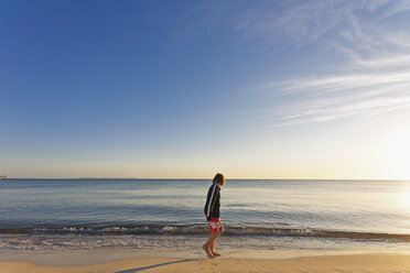 Spanien, Mallorca, Junge steht am Strand und beobachtet kleine Wellen - MEMF000743