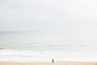Spanien, Mallorca, Eine Person mit Regenschirm geht am Strand entlang - MEM000746