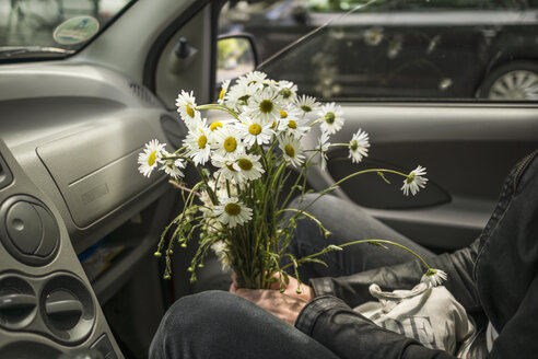 Frau mit Blumen im Auto sitzend - RIBF000060