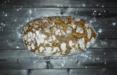 Krustiges Brot und gestreutes Mehl auf Holz - KSWF001533