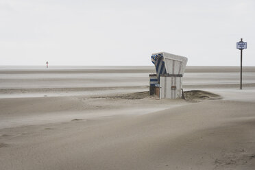 Germany, Schleswig-Holstein, St Peter-Ording, hooded beach chair in stormy weather - KEBF000193