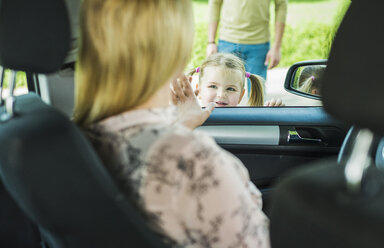 Girl saying goodbye to leaving mother in car - UUF004251