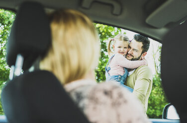 Mädchen mit Vater schaut Mutter im Auto an - UUF004252