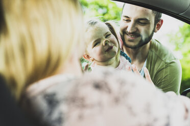 Mädchen mit Vater schaut Mutter im Auto an - UUF004253