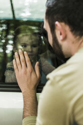 Mädchen im Auto schaut Vater hinter der Fensterscheibe an - UUF004257