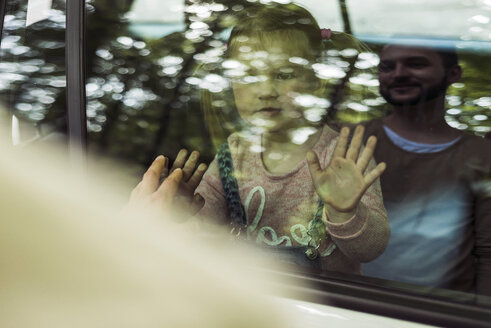 Mädchen im Auto schaut Vater hinter der Fensterscheibe an - UUF004258