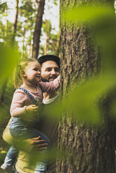 Girl with father in forest examining tree trunk - UUF004261