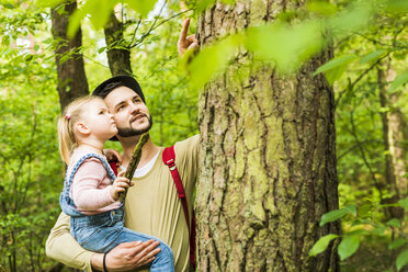 Mädchen mit Vater im Wald bei der Untersuchung eines Baumstamms - UUF004267