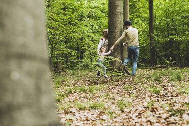 Familie im Wald läuft um einen Baumstamm - UUF004270