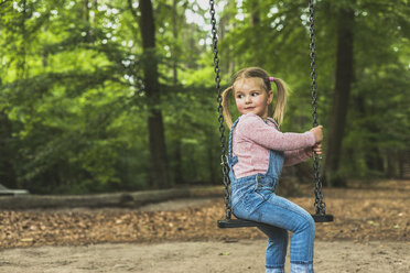 Smiling girl sitting on swing - UUF004279