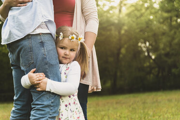 Girl embracing father's leg on meadow - UUF004324