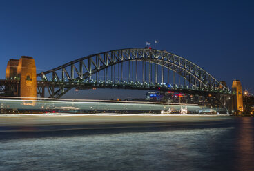 Australia, New South Wales, Sydney, Sydney Harbour Bridge with blurred ferry at dusk - JBF000244