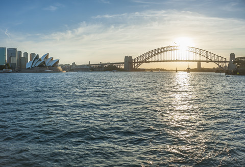 Australien, New South Wales, Sydney, Skyline mit Sydney Harbour Bridge und Sydney Opera House bei Sonnenuntergang, lizenzfreies Stockfoto