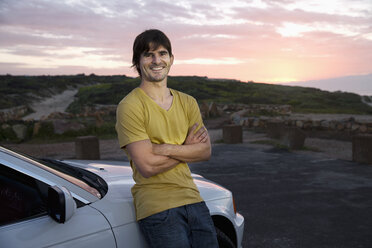 Südafrika, lächelnder Mann an geparktem Auto bei Sonnenaufgang - TOYF000618